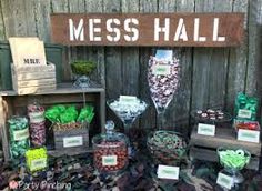 a table topped with lots of candy and candies next to a sign that says mess hall