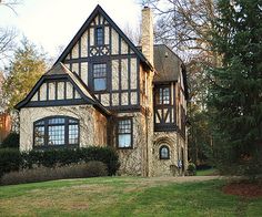 a large house sitting in the middle of a lush green field with lots of trees