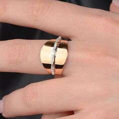 a close up of a person's hand with a gold and silver ring on it