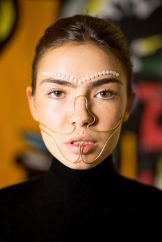 a woman with pearls on her face and nose