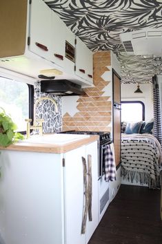 the interior of a camper with zebra print on the ceiling and bed in the back