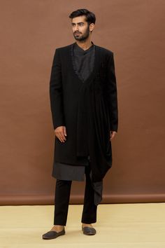 Black draped jacket with geometric embroidery. Paired with draped sherwani and pant.
Components: 3
Pattern: Embroidered
Type Of Work: Geometric
Neckline: Mandarin
Sleeve Type: Full
Fabric: Sherwani: Dola Silk, Jacket and Pant: Imported Japanese
Color: Black
Other Details: 
Draped jacket
Occasion: Wedding - Aza Fashions Festive Elegant Sherwani With Sheer Dupatta, Elegant Sherwani With Sheer Dupatta, Elegant Sherwani With Sheer Dupatta For Eid, Elegant Festive Straight Kurta Outerwear, Traditional Drape Unstitched Suit For Eid Reception, Elegant Sherwani With Sheer Dupatta For Diwali, Traditional Drape Nehru Jacket With Mirror Work For Eid, Nehru Jacket With Mirror Work For Eid, Festive Sherwani With Sheer Dupatta And Traditional Drape