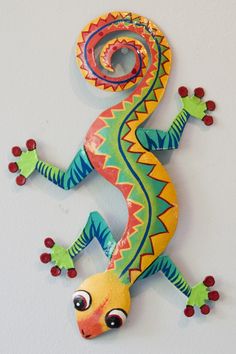 a brightly colored gecko is hanging on the wall