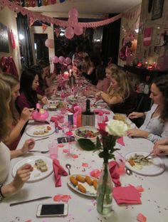 a group of women sitting around a table eating food