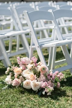 a bouquet of flowers sitting on top of a white wooden chair next to rows of chairs