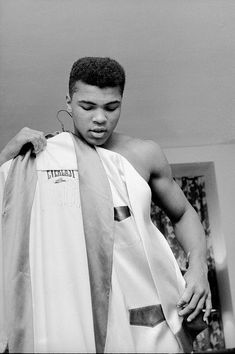 a black and white photo of a young man wearing a towel around his necktie