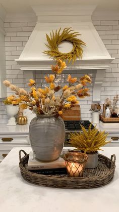 an image of a kitchen setting with flowers in the pot and candles on the counter