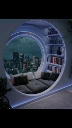 a living room filled with furniture and a round window overlooking the cityscape at night