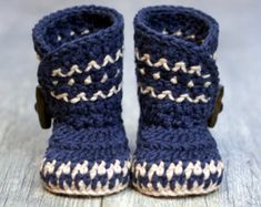 a pair of blue crocheted baby booties sitting on top of a wooden floor