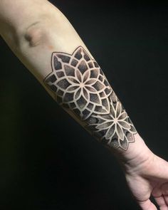 a person's arm with a tattoo on it and an intricate flower in the middle