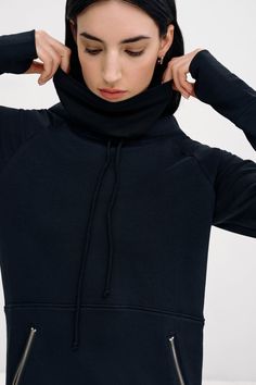 Enjoy maximum coverage in our Elba Sweatshirt Dress. Fashioned from our midweight, breathable European French Terry, she'll hug you all day in her full-body silhouette featuring an ankle-grazing hem and side vents. Zipped front pockets make space for essentials. And seamlessly attached to the hood is a gaitor mask you can raise up to the nose for added protection and insulation. | Emily, in black, is 5'9.5" (177 cm) tall, wearing size XS. Sam, in black and in olive, is 5'8" (173 cm) tall, wearing size XS. Total length approximately 55" (140 cm).Midweight European French Terry (95% Cotton; 4% Elastane).Machine wash cold or dry clean. Do not tumble dry. Do not bleach. Iron on low heat. Designed in NYC. Handcrafted in Europe. | Marcella Elba Long Sleeve Sweatshirt Dress in Black | Women's Siz Long Sleeve Sweatshirt Dress, Body Silhouette, Long Sleeve Sweatshirt, The A Team, Elba, Sustainable Fabrics, Sweatshirt Dress, Hug You, Petite Size