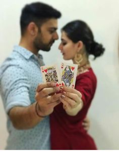 a man and woman holding playing cards in their hands