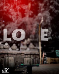 the word love is written in front of an outdoor table with benches and trash cans