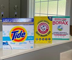 three boxes of tide products sitting on top of a counter next to a window sill