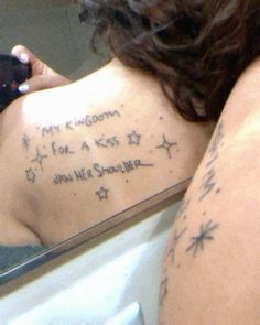 the back of a woman's upper body with writing on her left side and stars