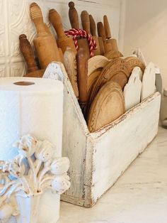 a wooden box filled with lots of different types of kitchen utensils and paper towels