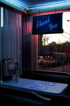 a table in front of a window with a thank you sign hanging from it's side