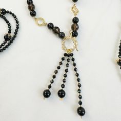 This elegant, feminine necklace set is a perfect addition to any look. Its black obsidian and smoky quartz stones are trimmed with a unique 14K gold plated brass chain, creating a look that will stand out from the crowd. Complete the look with matching earrings or bracelet for the perfect finishing touch. Perfectly pairing with a V neck top or midi dress, this necklace set is the ideal accessory for any night out. Keep the necklace away from perfumes, lotions, hairsprays, and other chemical substances. Black Faceted Crystal Necklace Elegant Style, Obsidian Necklace With Black Round Beads, Elegant Gold Smoky Quartz Necklace, Elegant Faceted Smoky Quartz Jewelry, Chemical Substances, Feminine Necklace, Smoky Quartz Necklace, Elegant Feminine, V Neck Top