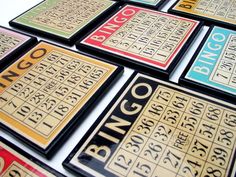 many different types of playing cards on a white table with black and yellow lettering that read bingo