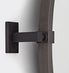 a close up of a wall mounted light on a white wall with a black metal frame