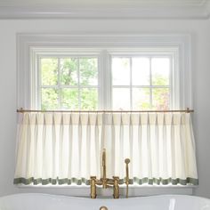 a white bath tub sitting under a window