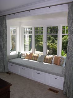 a large window seat with pillows on it