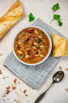 a bowl of soup with bread and parsley on the side