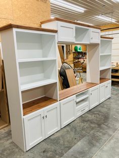 a room filled with lots of white cupboards and shelves on top of each other