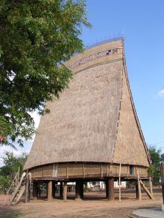 a large thatched roof structure with stairs leading up to it