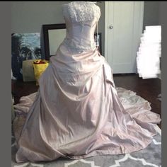 a wedding dress on display in front of a mirror with other items around the room