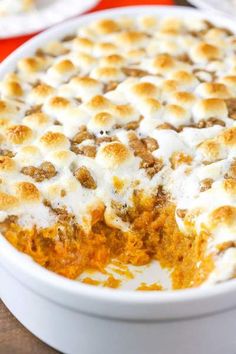 a casserole dish with marshmallows in it on a wooden table