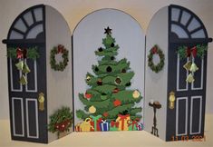 a paper christmas tree is displayed in front of two doorways with wreaths on them