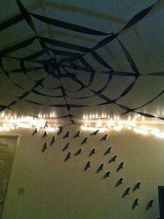 the ceiling is decorated with string lights and black bats hanging from it's sides