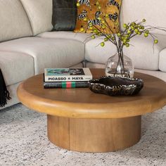 a living room with a couch, coffee table and books on the end tables in front of it