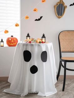 a white table topped with a black polka dot covered table cloth next to a chair