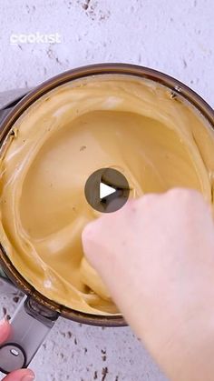 someone is using a knife to cut the cake batter in half and spread it on top