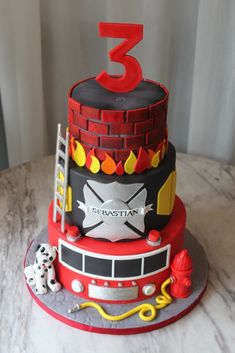 a birthday cake made to look like a firetruck with the number three on top