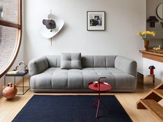 a living room filled with furniture and a large window next to a stair case in front of it