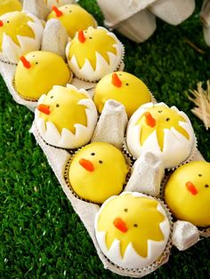 cupcakes with yellow frosting decorated as chicks in an egg carton on green grass