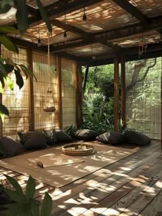 an outdoor room with lots of pillows on the floor and bamboo screens covering the walls