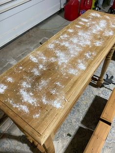 a wooden table covered in white powder on the floor