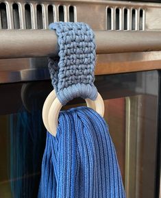 a close up of a blue tassel hanging from a metal door handle in front of an oven