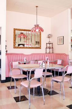 a restaurant with pink booths and checkered flooring, chandelier hanging from the ceiling