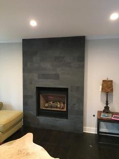 a living room with a fire place and couches in front of the fireplace that is built into the wall