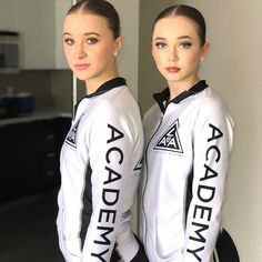 two young women standing next to each other in front of a mirror with the words academy on them