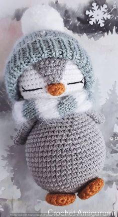 a crocheted penguin with a hat on it's head and eyes closed