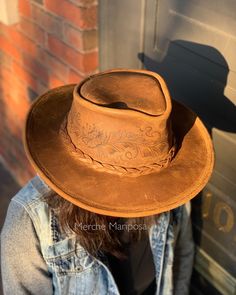 "This wide brim leather hat was made by the brand Minnetonka; I etched it free-hand with an earthy, floral design! The hat features durable distressed leather, and a hidden steel wire in the brim.  Measured by circumference:  Small: Head Measurement of 21 1/8\" - 21 1/2\" Medium: Head Measurement of 21 7/8\" - 22 1/4\" Large: Head Measurement of 22 5/8\" - 23\" X-Large: Head Measurement of 23 1/2\" - 24\" Hi! My name is Merche and I've been a henna artist since 2013. I discovered my skills are transferable to another awesome form of art...leather pyrography! As each pattern is drawn freehand, every shoe is slightly unique and one-of-a-kind. All patterns are Merche Mariposa originals, designed by me!  Have an excellent idea of your own? Send me a message. I absolutely love custom orders! ww Wide Brim Distressed Brown Hat For Country Events, Distressed Brown Wide Brim Hat For Country Events, Country Style Distressed Brown Flat Brim Hat, Distressed Brown Wide Brim Hat For Ranch, Rustic Hat With Distressed Brown Curved Brim, Rustic Hat With Distressed Brown Color And Curved Brim, Rustic Hat With Curved Brim In Distressed Brown, Distressed Brown Adjustable Hat With Flat Brim, Distressed Brown Adjustable Flat Brim Hat