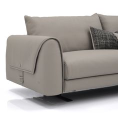 a gray couch with two pillows on it's back and one arm facing the camera