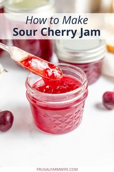 a jar filled with sour cherry jam next to some cherries