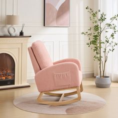 a pink rocking chair sitting in front of a fire place